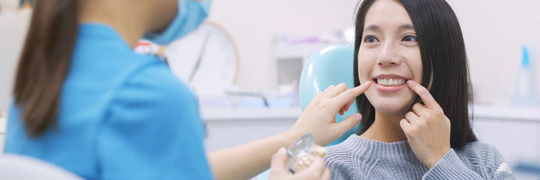 A woman smiling while having her teeth examined, showcasing dental health awareness in Garland, TX.