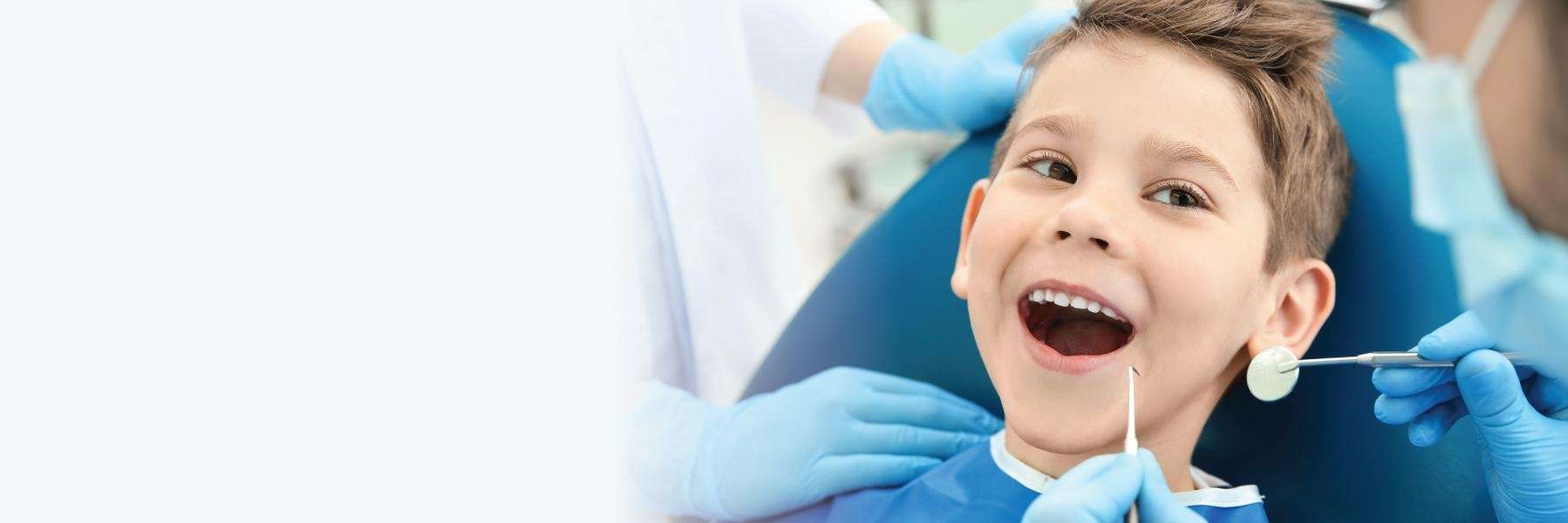 young boy smiling in dental clinic chair | dentist in garland tx
